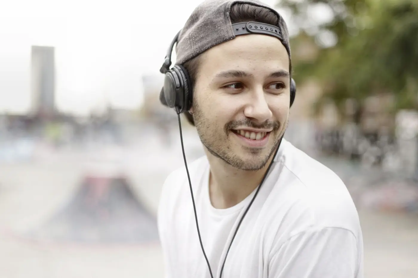 A smiling man wearing headphones outdoors